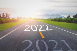 conceito de ano novo com a palavra 2021 a 2022 escrita na estrada de asfalto foto