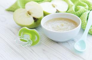 tigela com comida de bebê de frutas e maçãs foto