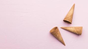 cones de waffle em fundo de textura rosa