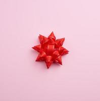 grande vermelho lindo arco em uma Rosa fundo, uma festivo elemento para a desenhista, cópia de espaço foto
