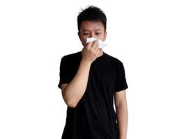 jovem homem dentro Preto camisa segurando nariz com lenço de papel com em linha reta face expressão isolado em branco fundo foto