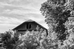 linda e velha casa de fazenda abandonada na zona rural em fundo natural foto