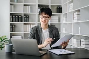 jovem o negócio homem executivo Gerente olhando às computador portátil assistindo conectados webinar Treinamento ou tendo virtual encontro vídeo conferência fazendo mercado pesquisa trabalhando dentro escritório. foto