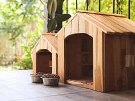 dois esvaziar de madeira cachorro casas com cachorro Comida taças dentro sacada decorado com planta de casa dentro plantar potes. foto