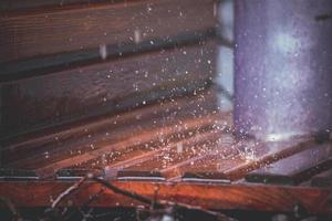 fechar-se do gotas queda em uma de madeira fundo dentro a urbano graduação torre foto