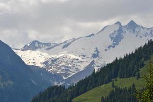 montanhas coberto com neve e verde prados - Alpes montanhas dentro Áustria foto