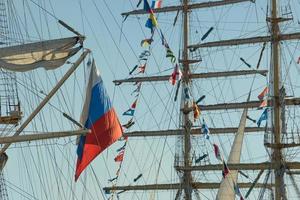 o mastro do veleiro e a bandeira russa contra o céu azul.
