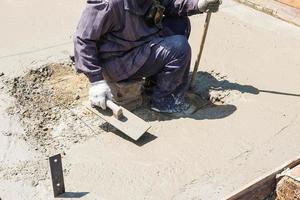 trabalhadores da construção civil rebocando cimento foto