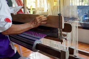 ásia fêmea tecelãs tecelagem tradicional padrões com mão tecelagem máquinas.in a conceito do otop, comunidade produtos, mão tecelagem tecidos, comunidade lojas, comunidade tecelagem centros. foto