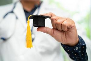 estudo de médico asiático aprende com chapéu de graduação na enfermaria do hospital, conceito de medicina de educação de gênio brilhante inteligente. foto