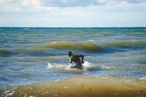 um surfista solitário treina em pequenas ondas no mar Báltico foto