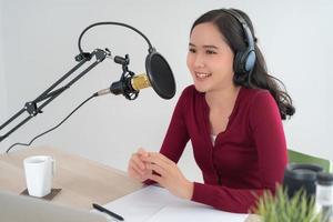 Ásia mulher é Falando para encorajar em uma rádio transmissão estação. lindo fêmea organizado a rádio programa. rádio, podcast, viver fumegante, entretenimento, ouvir, tecnologia, música, alto falante foto
