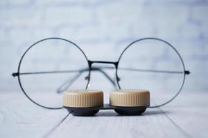close-up de lentes de contato e óculos na mesa foto