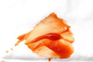 tomates e ketchup mancha em branco camisa roupas fechar acima foto