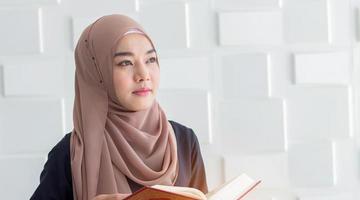 jovem muçulmana vestida com um hijab preto, orando por Alá, copie o espaço. conceito de rituais religiosos para a paz foto