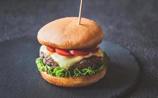 hambúrguer na placa de pedra preta foto