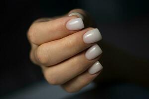 lindo nu manicure. manicure para mulheres com gel polonês. leitoso quadrado curto unhas foto