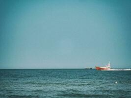 branco e vermelho mar resgate embarcação Navegando em a polonês báltico mar contra a azul céu em uma caloroso verão dia foto