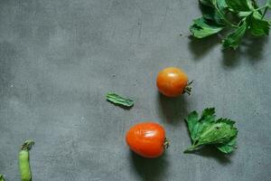 fresco tomates e fresco legumes a partir de topo Visão em concerete fundo foto