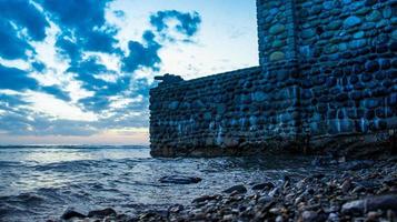 parede de pedra com uma arma no fundo da paisagem do mar. foto