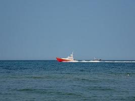 branco e vermelho mar resgate embarcação Navegando em a polonês báltico mar contra a azul céu em uma caloroso verão dia foto