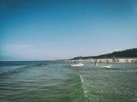 verão panorama acima a báltico mar em uma caloroso ensolarado dia com azul céu e pessoas em repouso dentro a fundo foto