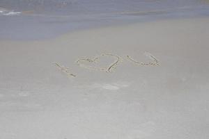 inscrição em a areia em a mar costa Eu amor você foto