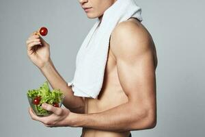 homem com uma bombeado acima corpo em dele ombros prato do salada saudável Comida cortada Visão foto