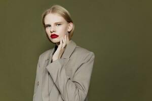 retrato do uma mulher com vermelho lábios detém mão perto face estúdio modelo inalterado foto