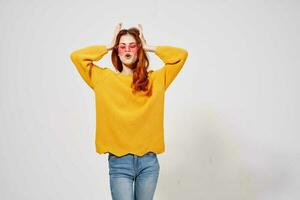 bonita mulher dentro uma amarelo suéter Penteado posando estúdio Diversão modelo foto