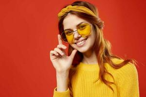 alegre mulher dentro amarelo óculos suéter hipster moda retro estilo foto