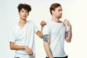 dois homens dentro branco Camisetas ficar de pé lado de lado cortada Visão estúdio foto