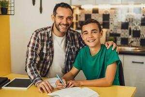 pai é ajudando dele filho com aprendizado. elas estão fazendo dever de casa junto. foto