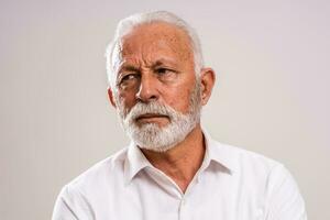 retrato do uma Senior homem dentro uma branco camisa foto