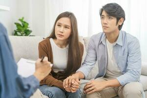 psicologia, depressão ásia jovem casal, paciente consultando problema mental saúde com psicólogo, psiquiatra às clínica junto, marido encorajando de segurando mão do esposa, terapia saúde Cuidado foto