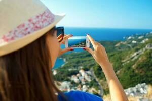 menina dentro chapéu fazer fotos do a adriático mar de a Smartphone