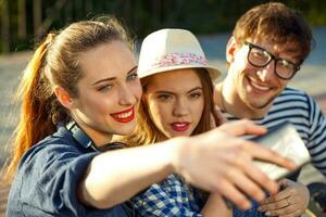 sorridente amigos fazer selfie ao ar livre foto