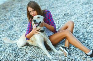 mulher com uma cachorro em uma andar em a de praia foto