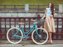 jovem elegantemente vestido mulher com bicicleta, verão e estilo de vida foto