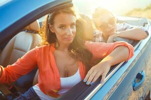 dois jovem feliz meninas dirigindo uma cabriolet foto