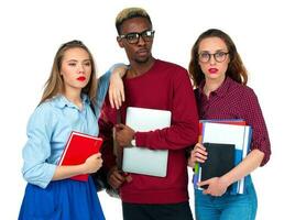 três feliz alunos com livros, computador portátil e bolsas isolado em branco foto