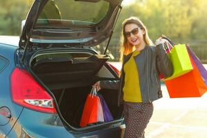 mulher colocando dela compras bolsas para dentro a carro tronco foto