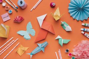 conjunto de arte em papel origami e pincel com aquarela e canudos em fundo laranja