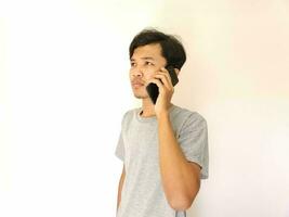 ásia jovem homem em a telefone com uma Smartphone isolado em branco foto