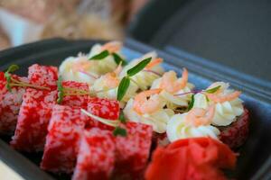 uma conjunto do Sushi e rolos dentro uma Preto caixa decorado com microgreens. Comida Entrega. Califórnia rolos com camarão. foto