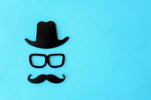 feliz pais dia adesivo, Preto chapéu, óculos e bigode em uma azul fundo. hipster objetos. do pai dia é uma feriado. Projeto em branco espaço para rotulação. foto