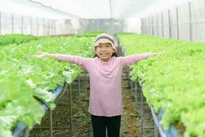 feliz menina sorridente e apresentando orgânico vegetal Fazenda foto