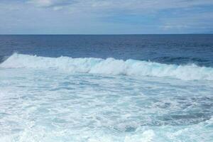 ampla ondas falhando contra a pedras dentro a oceano foto