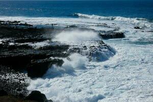 ampla ondas falhando contra a pedras dentro a oceano foto