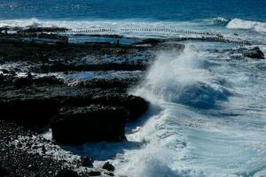 ampla ondas falhando contra a pedras dentro a oceano foto